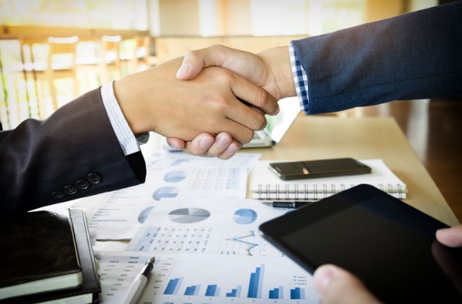 dos personas apretando las manos por los beneficios del factoring para empresas
